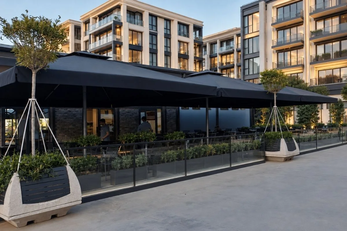 İstanbul Büyük Şemsiye | Modern Restaurant Terası Projesi İstanbul’da modern restaurant terasında siyah büyük şemsiye sistemleri ve açık alan oturma düzeni