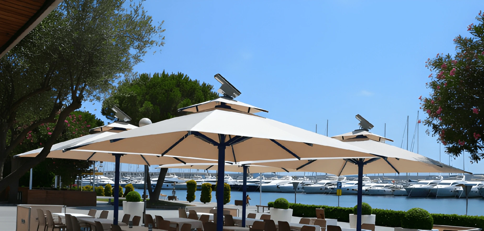 Marina restaurantında krem kumaşlı solar LED teleskopik şemsiyeler